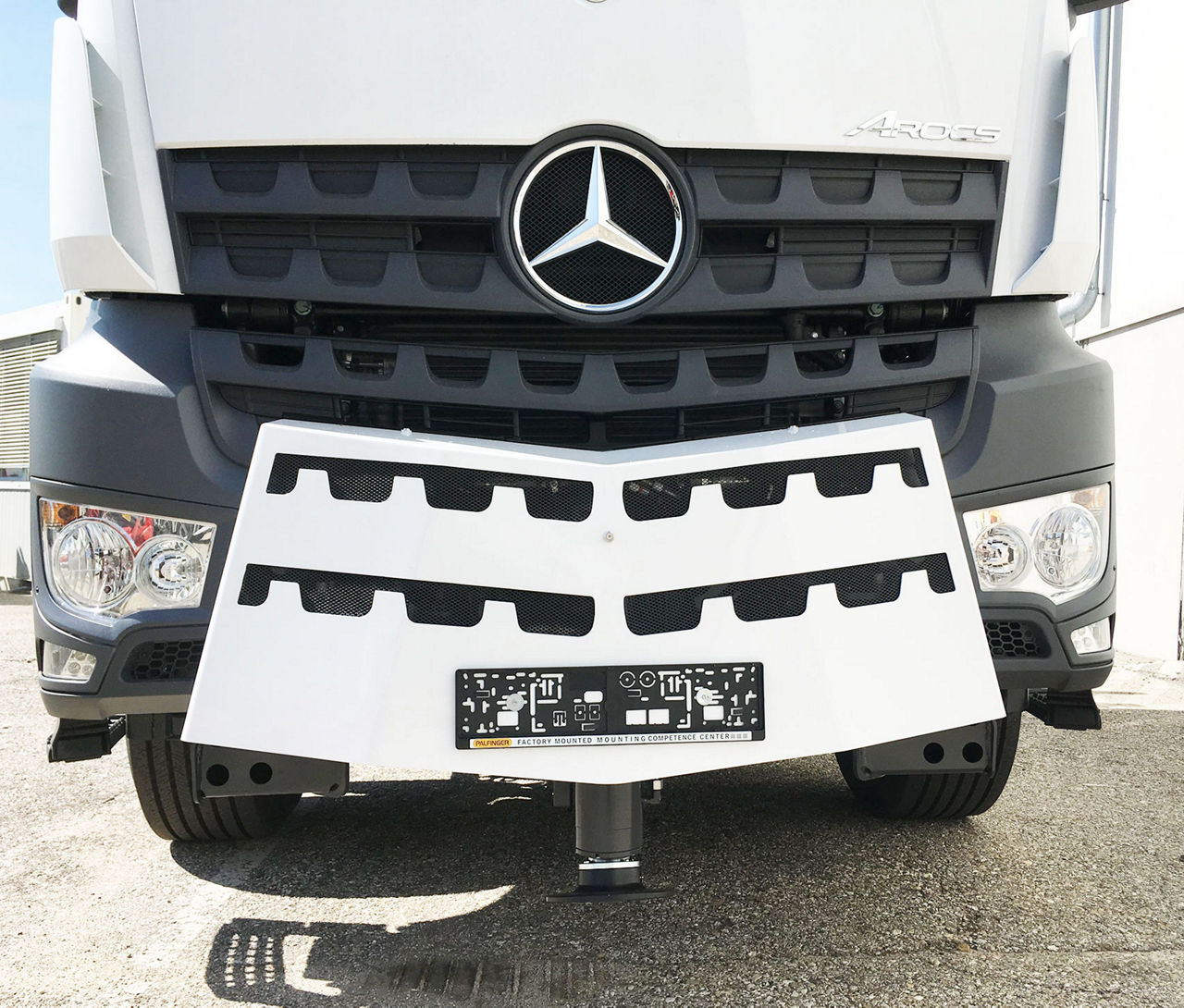 Front view of a Mercedes-Benz truck with a PALFINGER front stabilizer kit mounted below the bumper