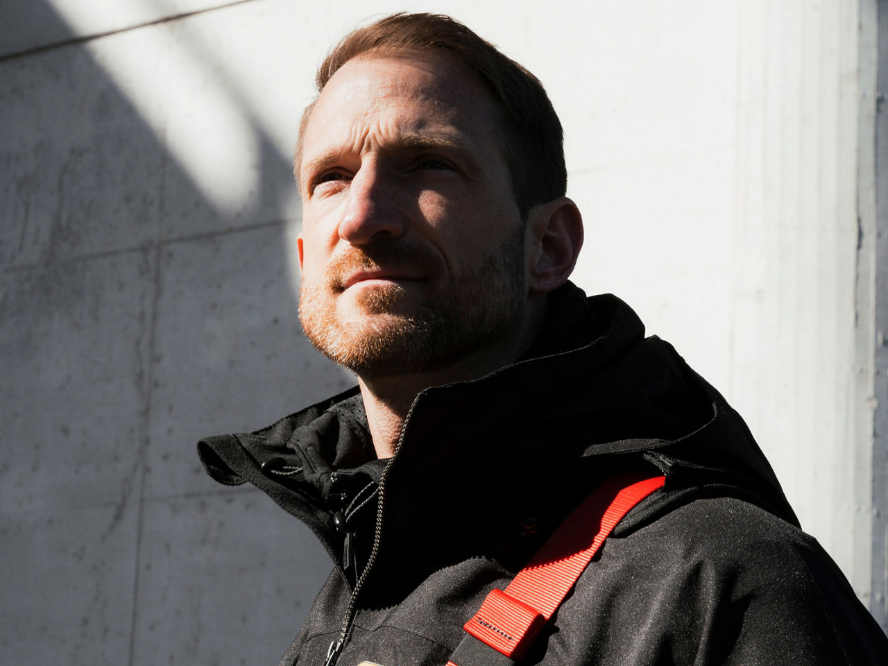 Worker wearing protective clothing, looking into the distance in an industrial setting, conveying confidence, expertise, and human focus.