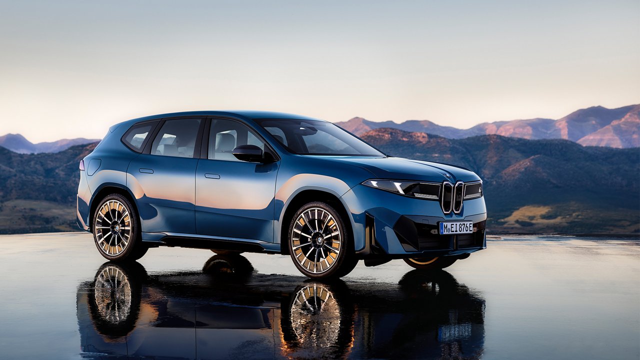 bmw ix3 på en glasliknande yta med vy över berg