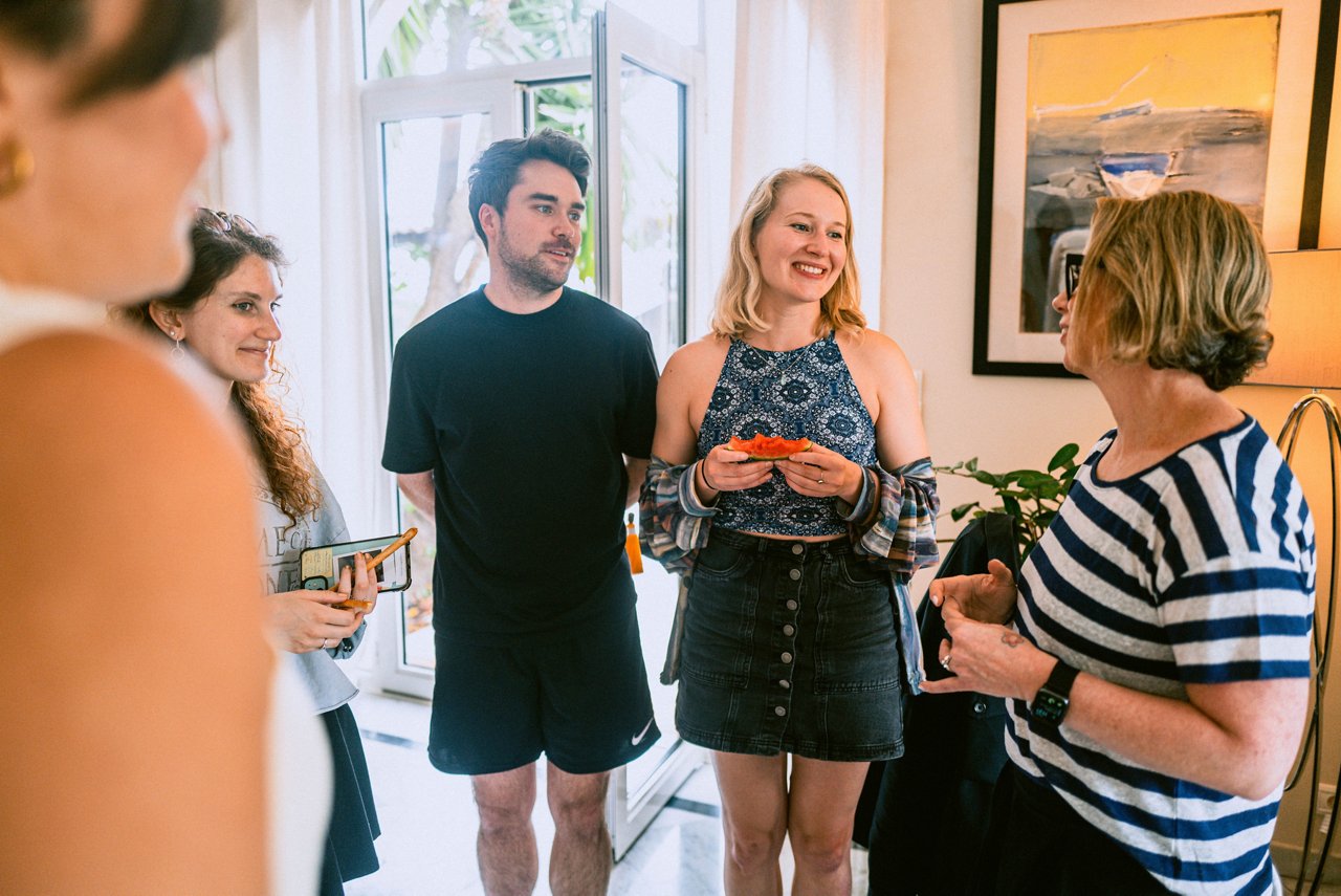 Spark Academy 2025 in Cannes: Small group engaged in casual conversation. One woman is eating a slice of tomato, others hold notes or drinks.