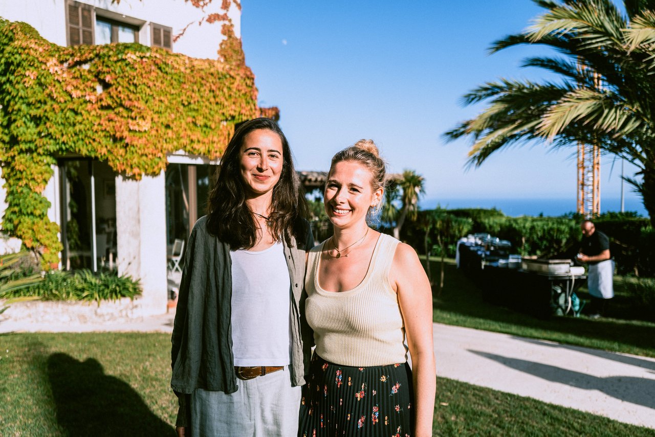 Spark Academy 2025 in Cannes: Two women stand side by side in the golden evening light, in front of an ivy-covered villa with a view of the sea.