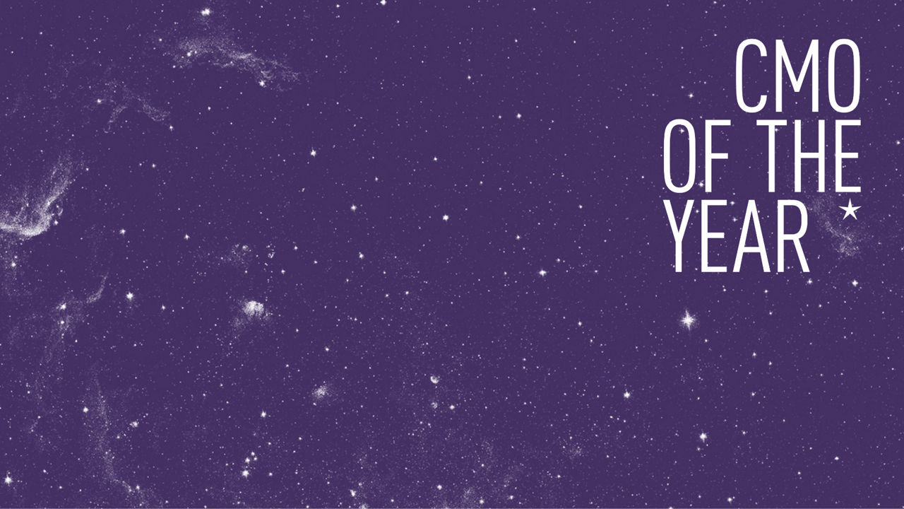 Grafische Darstellung mit einem violetten Hintergrund, der ein Sternenfeld oder eine Galaxie zeigt. Rechts im Bild steht in großen weißen Großbuchstaben: „CMO OF THE YEAR“ mit einem Sternsymbol daneben. Der Text ist zentriert im rechten oberen Drittel der Darstellung platziert, während der Rest des Bildes frei von Text ist.