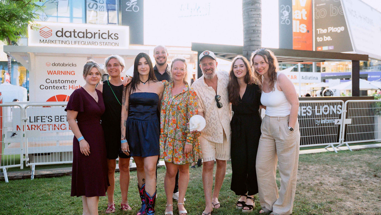 The winning team behind "The Period Uniform" poses together outdoors at the Cannes Lions Festival 2026, with festival signage and the Palais des Festivals visible in the background.