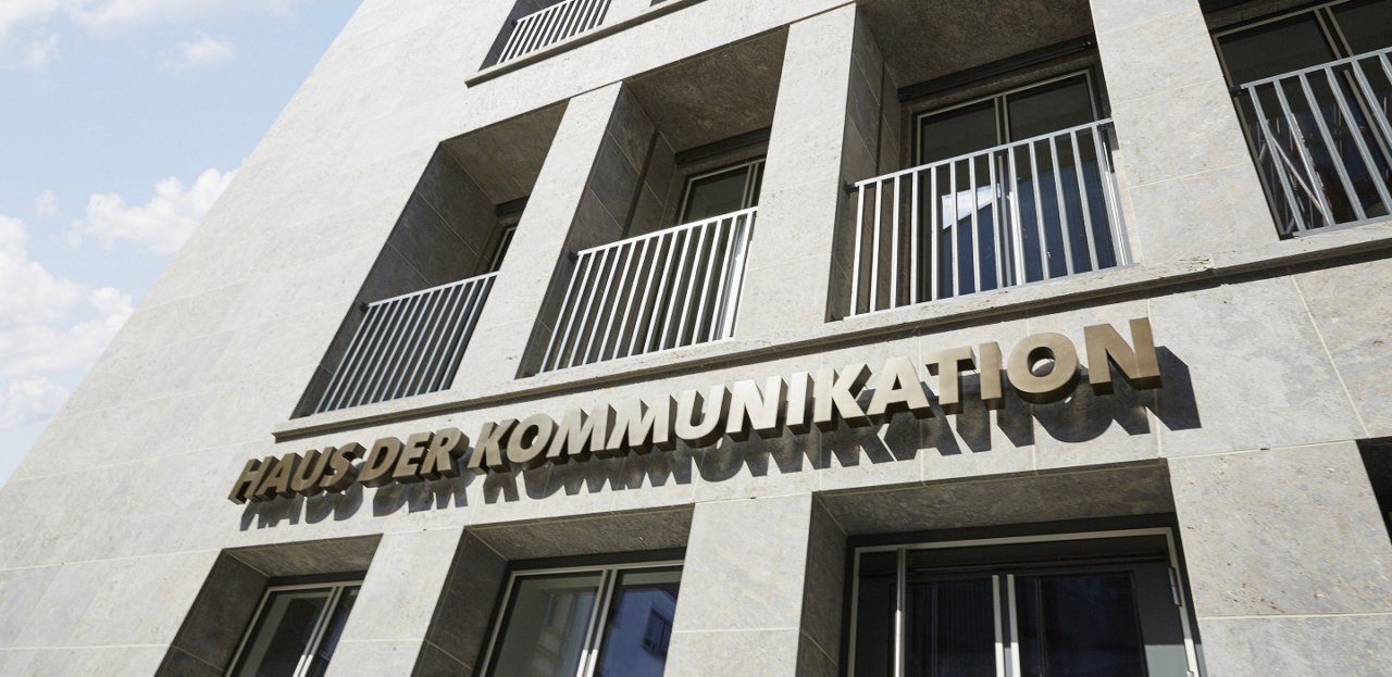 Exterior view of the HoC Berlin building with the Haus der Kommunikation logo