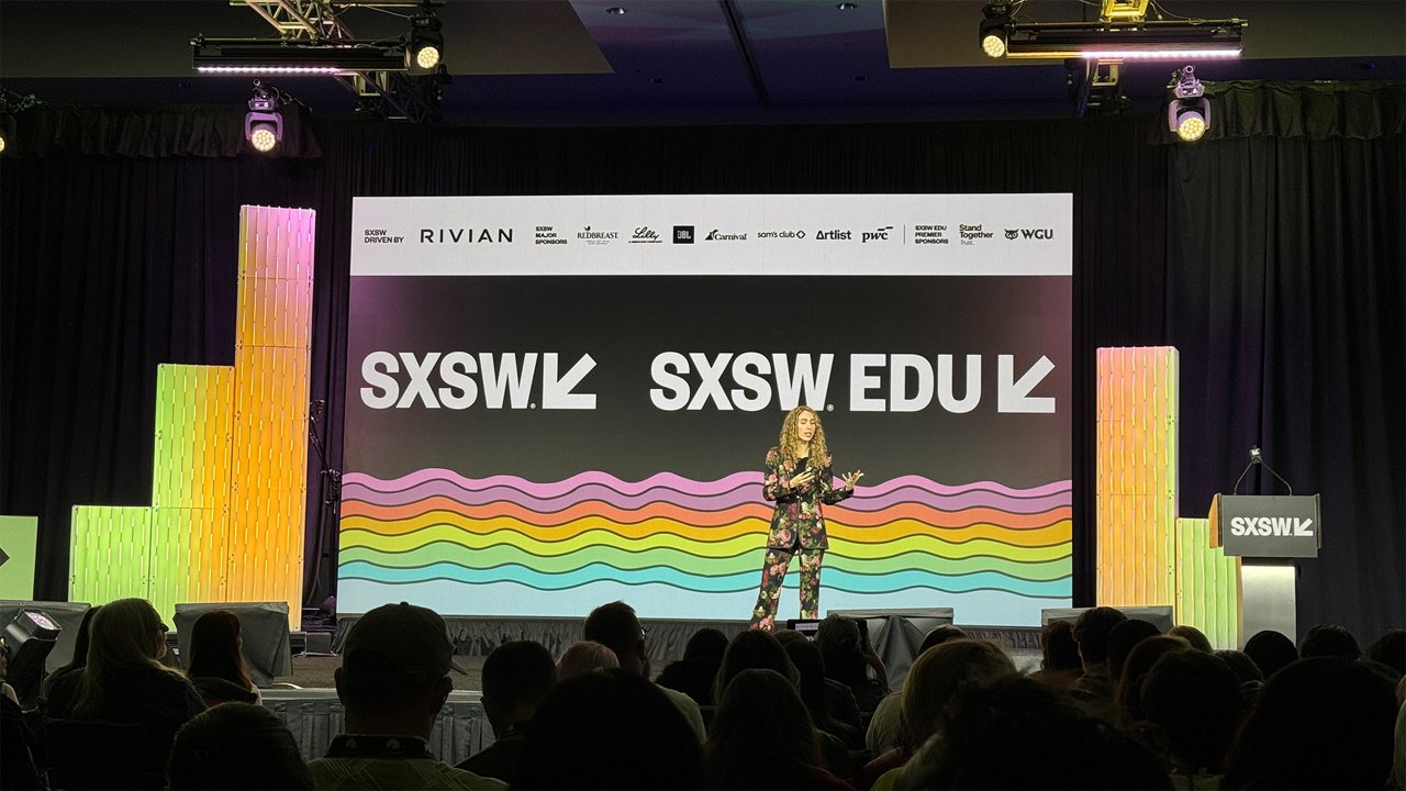 A speaker presents on the SXSW EDU stage in front of a large screen displaying the SXSW logo and colorful wave graphics.