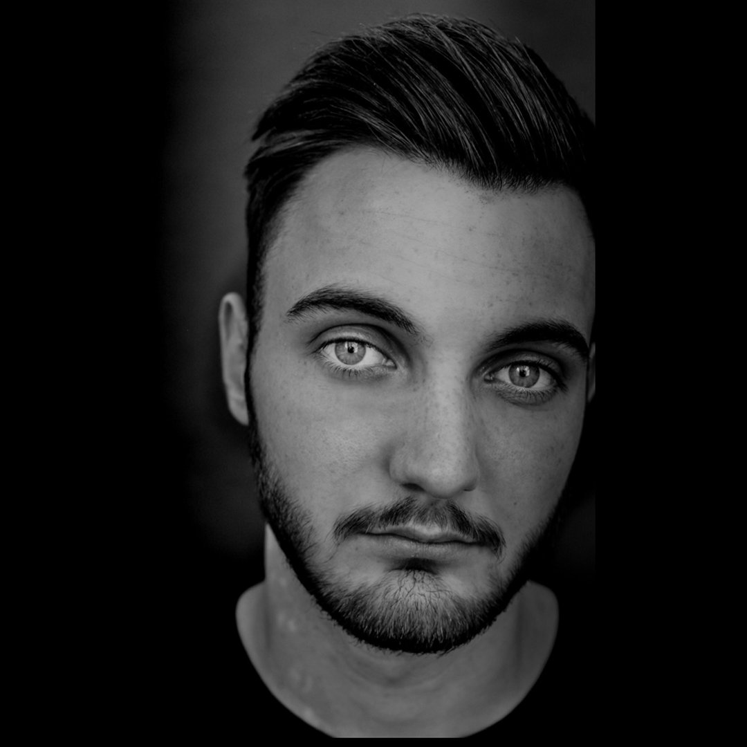 Luca Dippold in a black and white close-up portrait, looking directly at the camera.