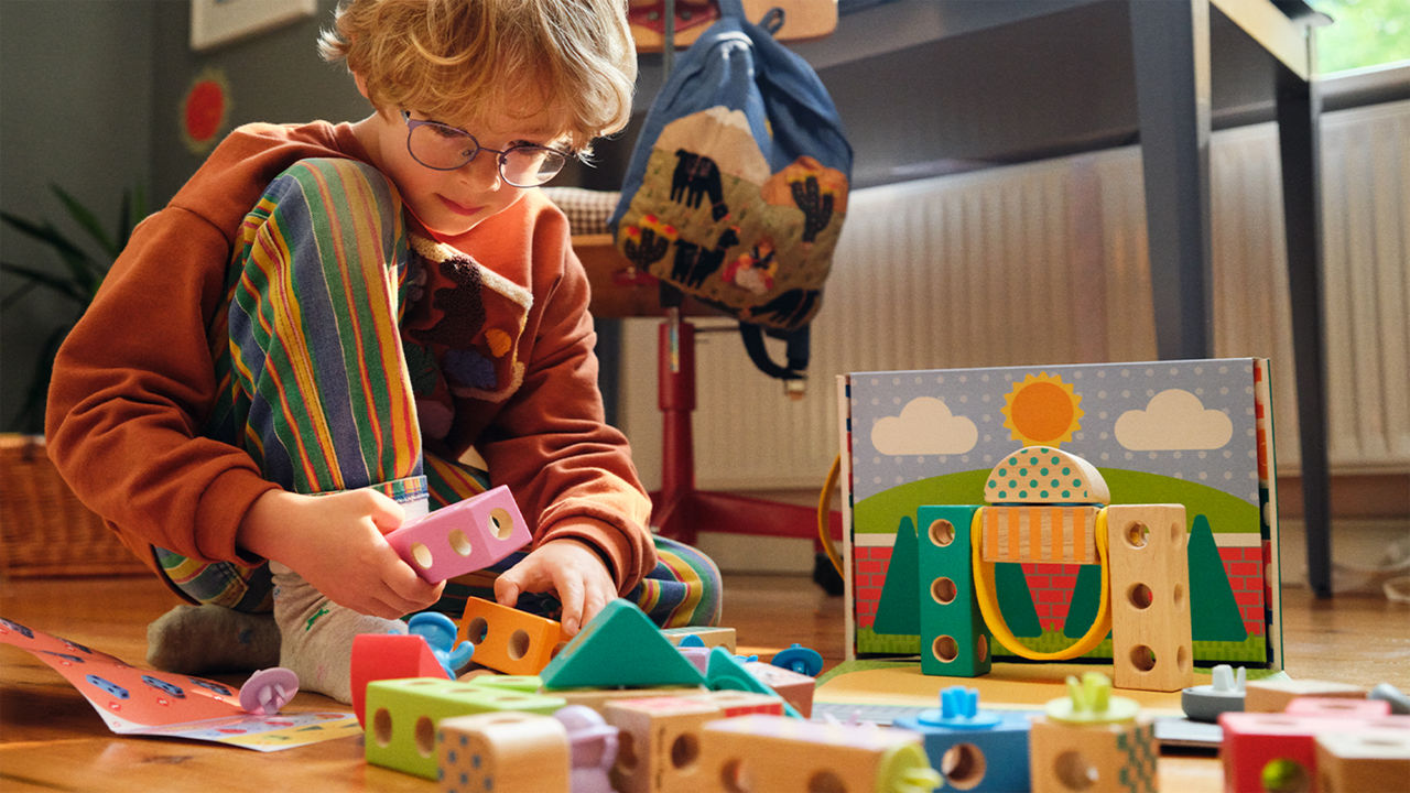 A child plays with colorful wooden toys from Melissa & Doug – promoting creative learning and free play.