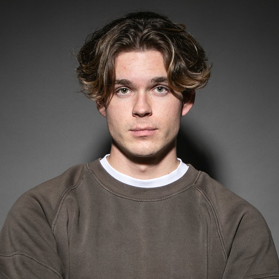 Michael Winnicki in a studio portrait against a grey background, looking directly at the camera.