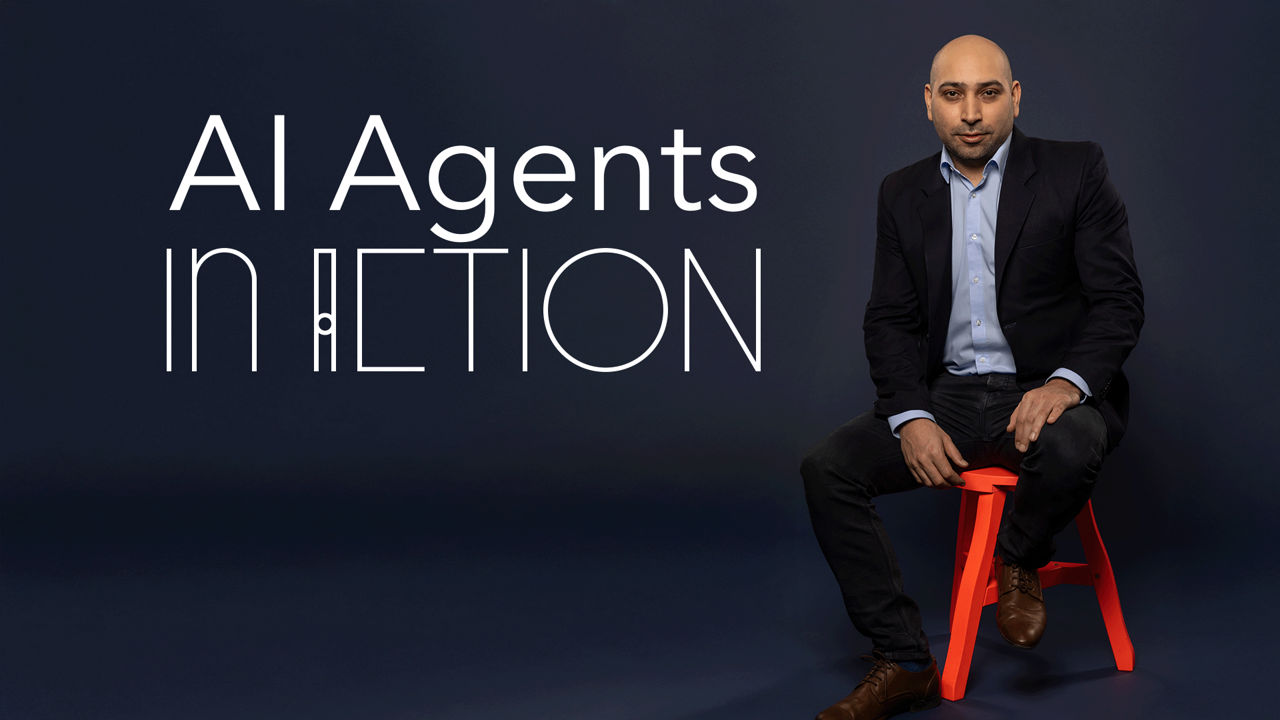 Lotfi Hadi, a man with a shaved head and light skin tone, is seated on a bright red stool against a dark blue background. He is wearing a navy blazer and a light blue shirt, looking directly at the camera. On the left side, large white text reads ‘AI Agents in Action’ in a modern, stylized font.