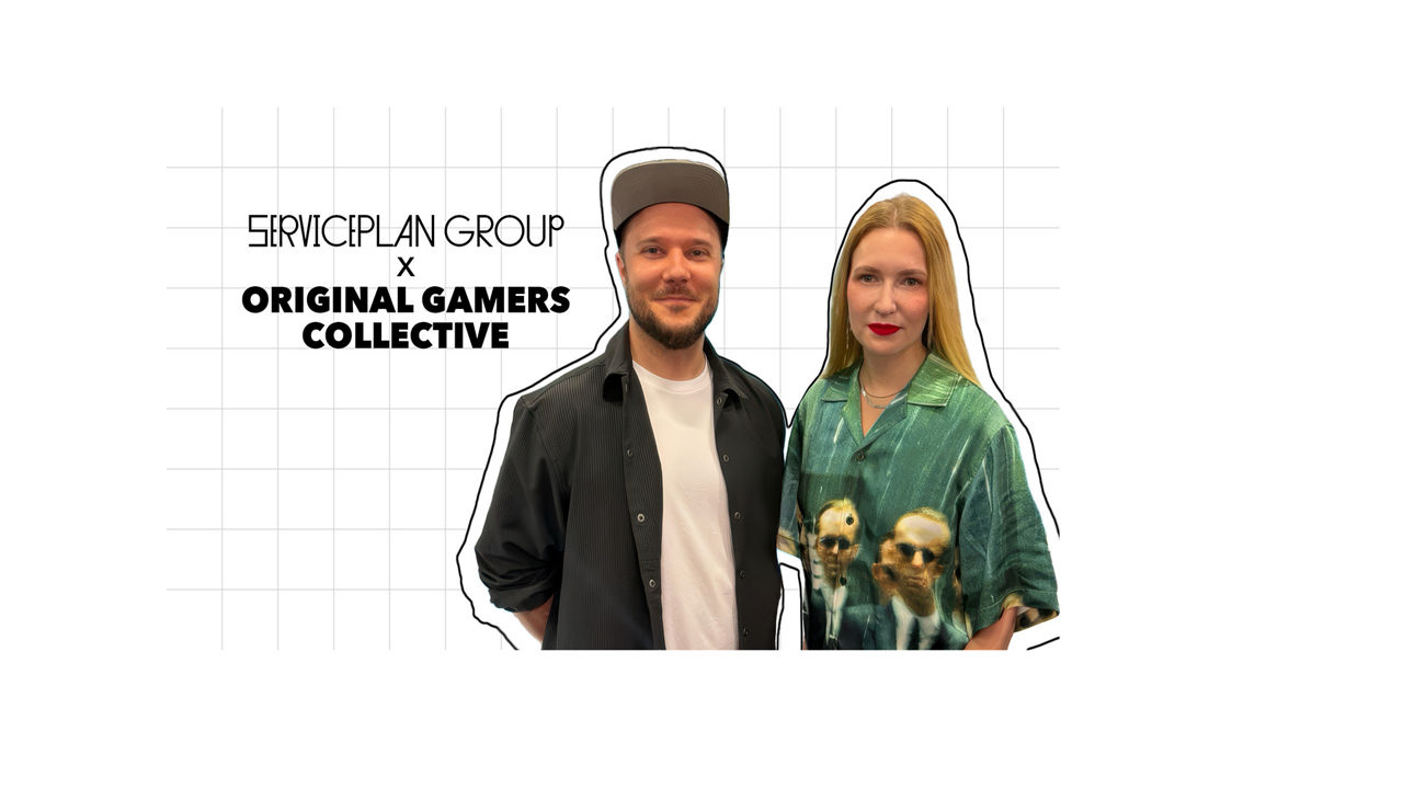 Two people are standing in front of a graphic background featuring the words “Serviceplan Group x Original Gamers Collective”. The graphic visualizes the collaboration between Serviceplan Group and Original Gamers Collective.