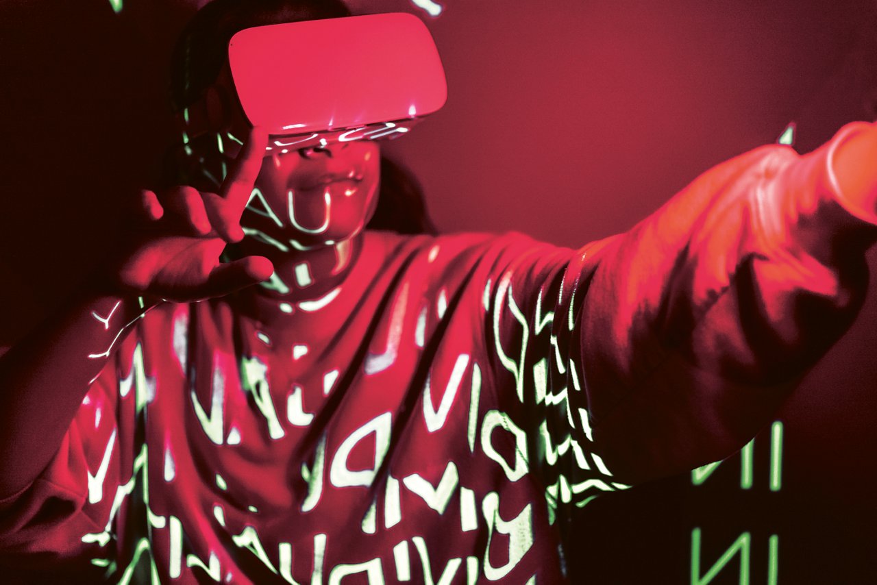Crimson red technological concept with a person in VR glasses and Individuality projection. Vibrant tone of 2023 in gaming and esports concepts. Futuristic Metaverse in neon lights