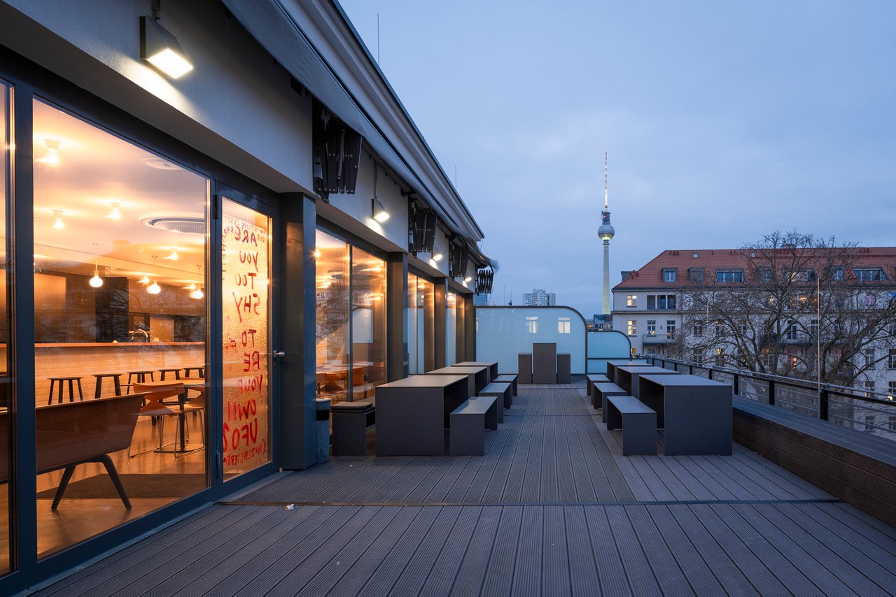 Roof terrace of the Berlin office in the evening. The television tower can be seen in the background