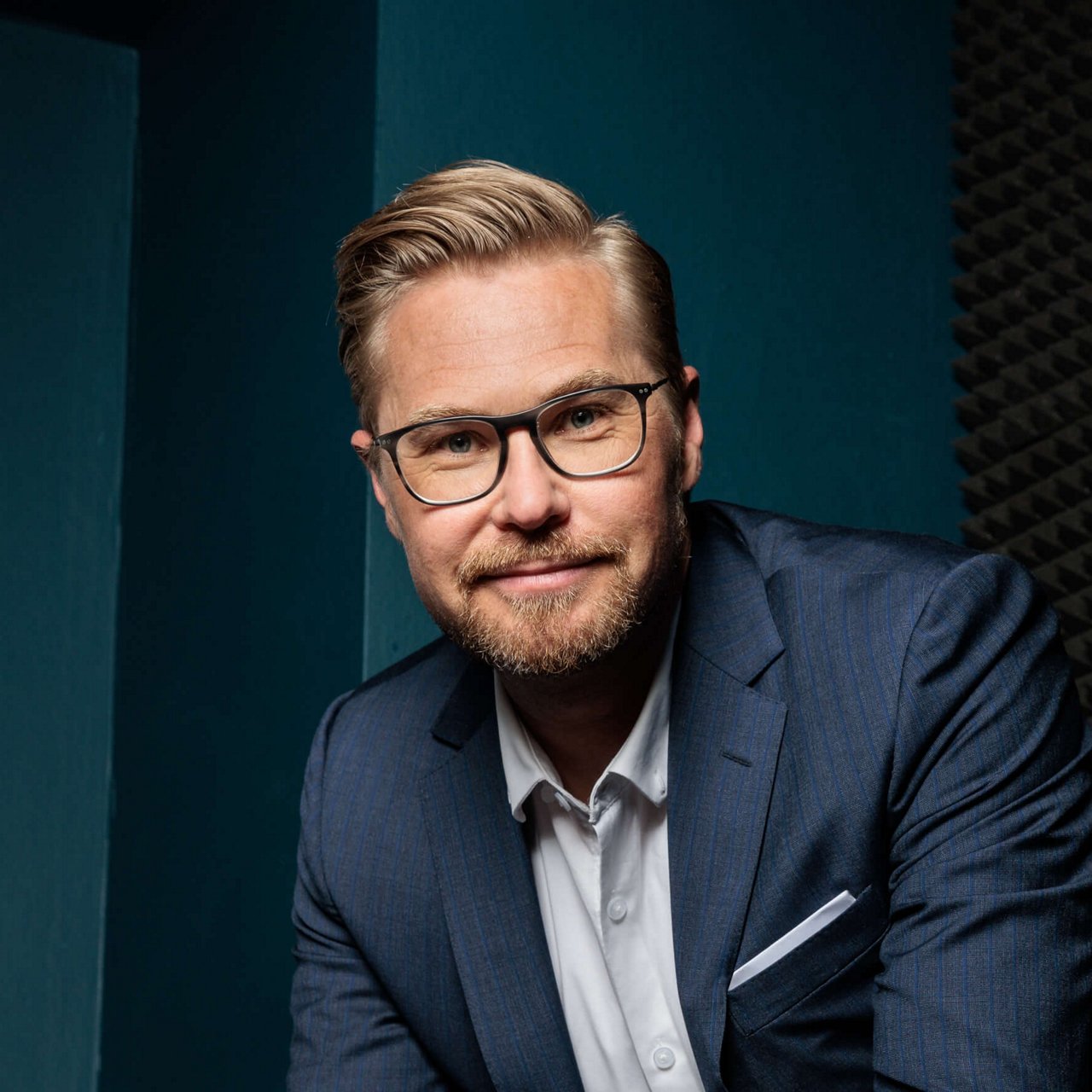 Foto Felix Bartels im Anzug vor blauem Hintergrund