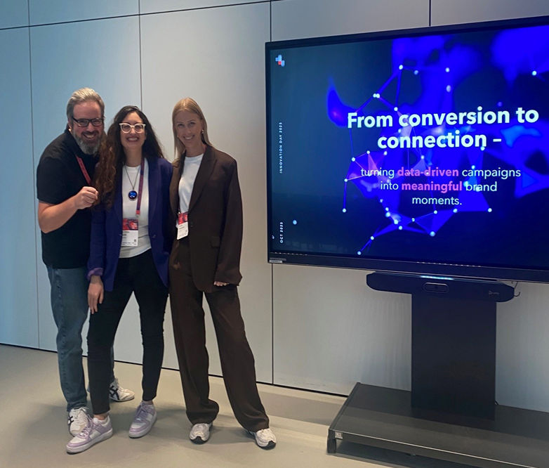 Three people standing in front of a large screen that says: From conversion to connection