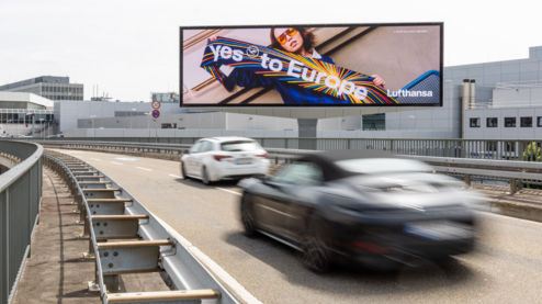 Lufthansa Werbekampagne am Rande einer Autobahn worauf eine Frau mit einem Fußball-Fanschal unter dem Motto: 'Yes to Europe' zusehen ist