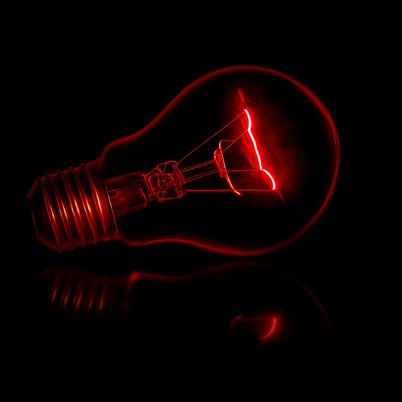 A glowing red light bulb on a dark background symbolizing creativity and innovation