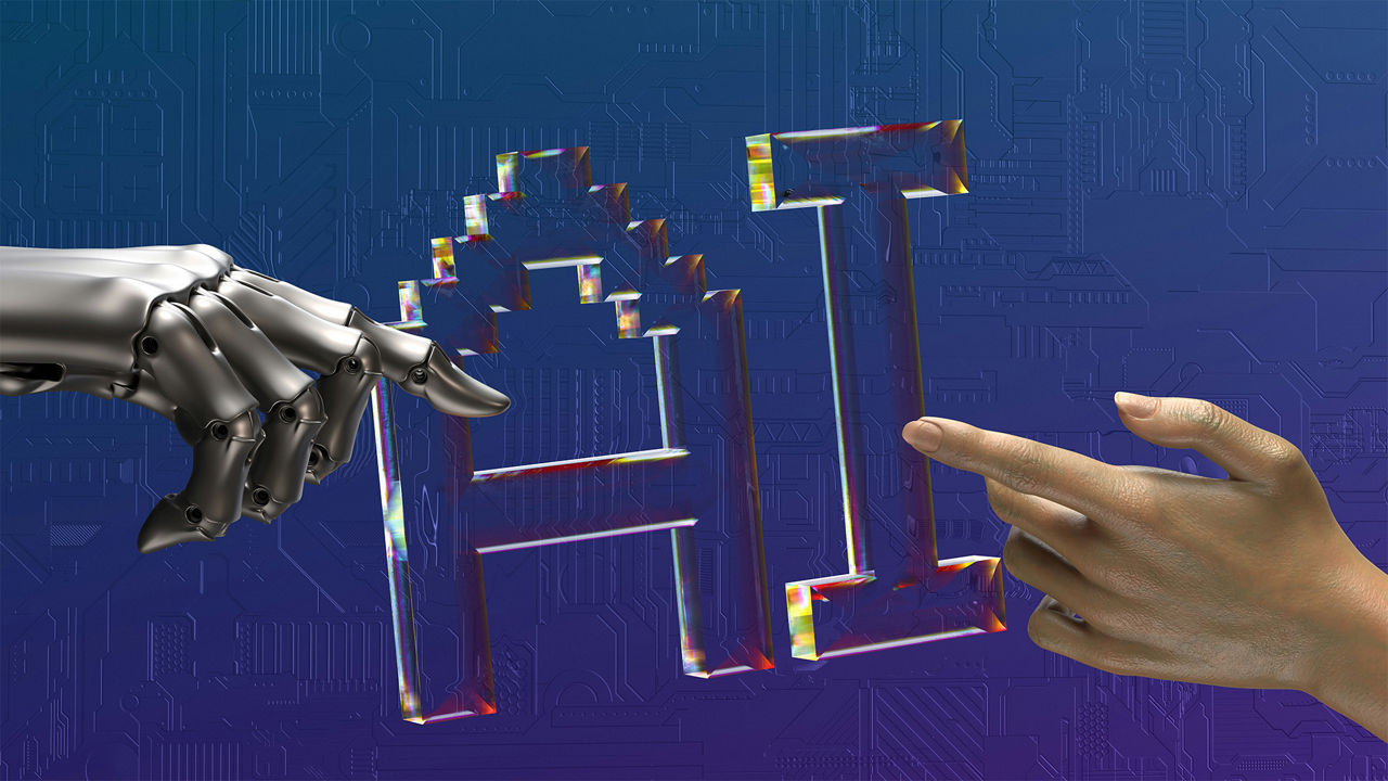 A silver robotic hand and a human hand touch the transparent, rainbow-colored letters “AI” (Artificial Intelligence) against a blue background featuring a circuit board pattern.