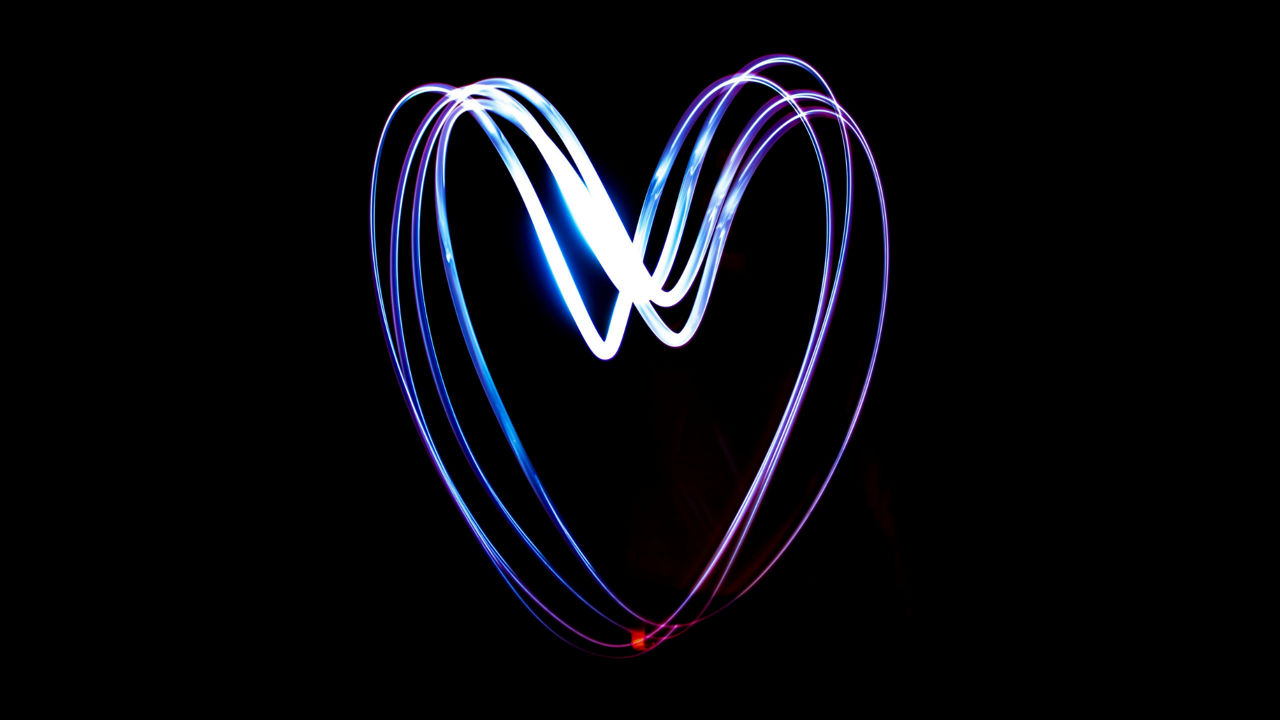 A laser light painted heart in bright blueish colors on a black backround