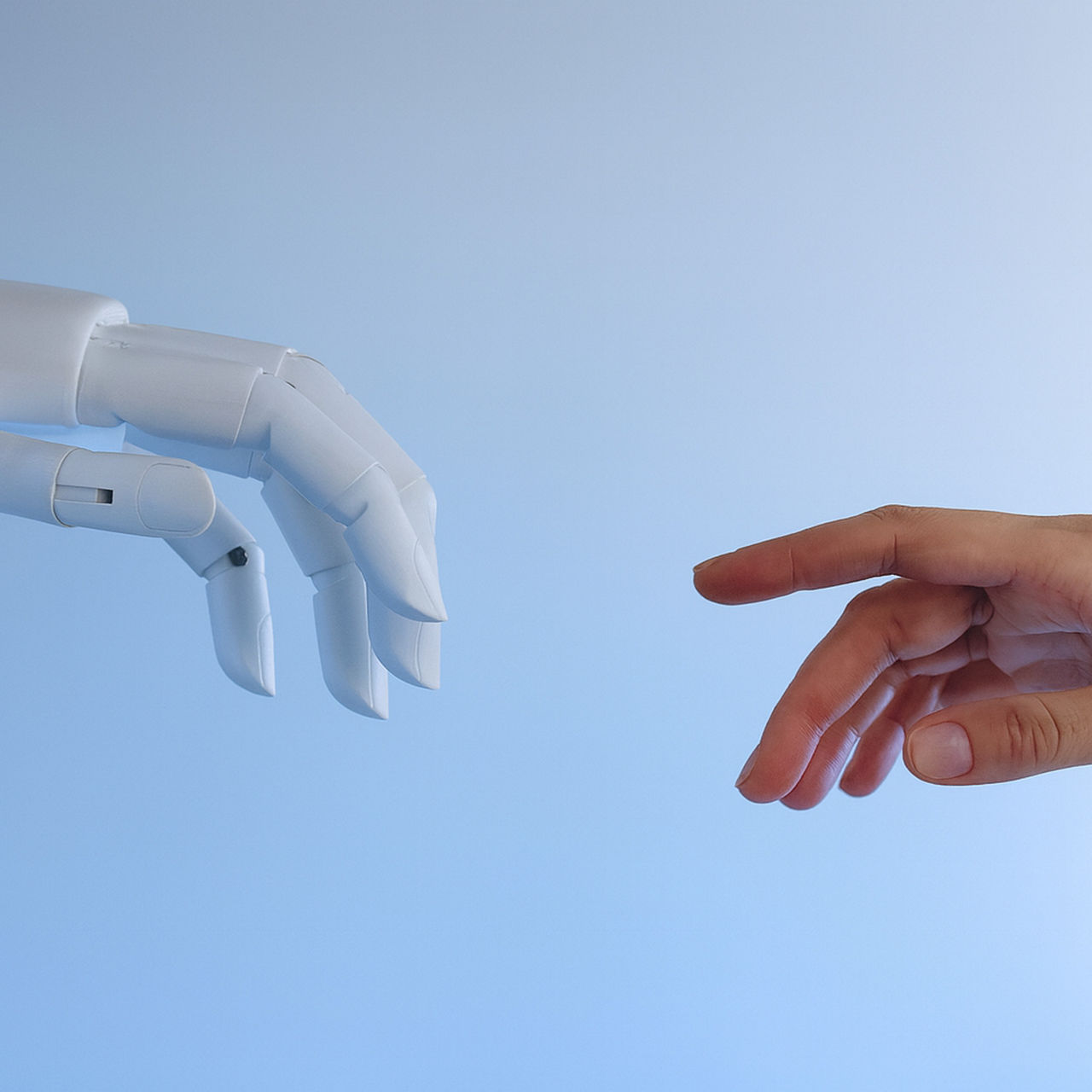 A robot hand and a human hand reaching toward each other against a blue background