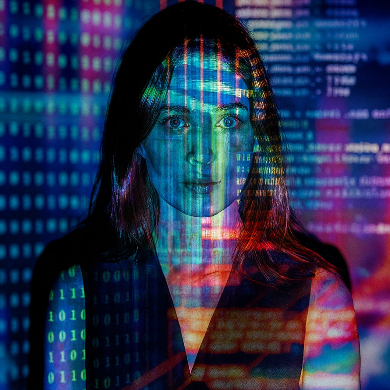 A woman’s face overlaid with colorful digital code and binary numbers