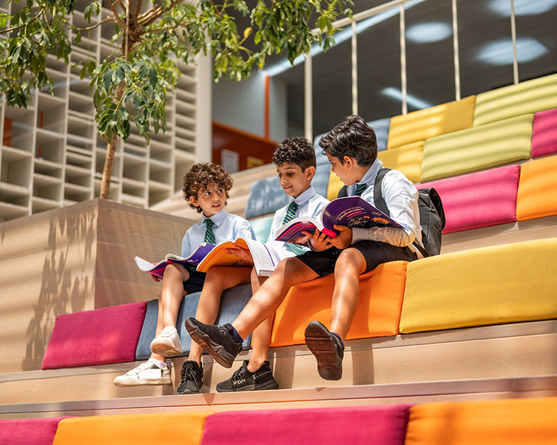 Students reading and studying together in a vibrant learning space, representing Qiddiya City’s commitment to education, lifelong learning, and future schools within the city