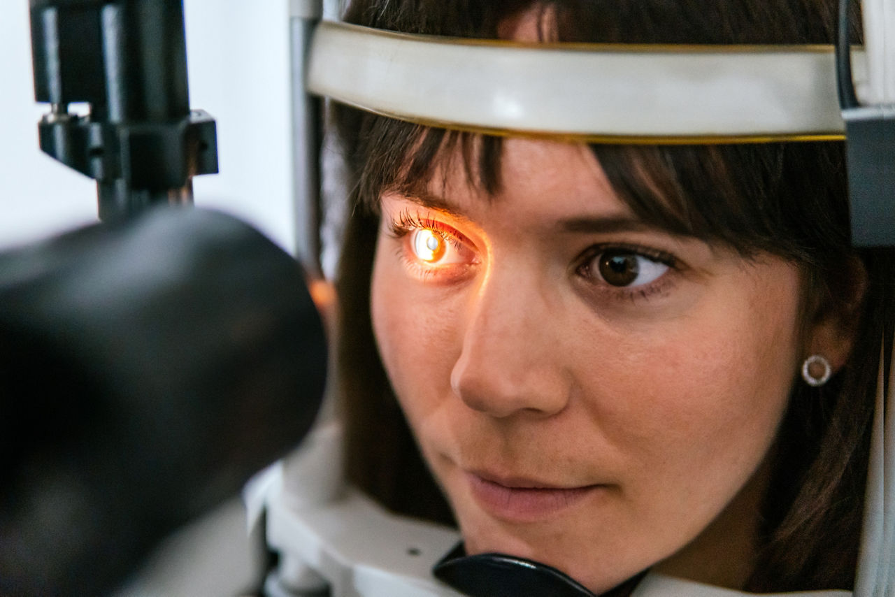 oculist looking at the eye with a machine to a patient