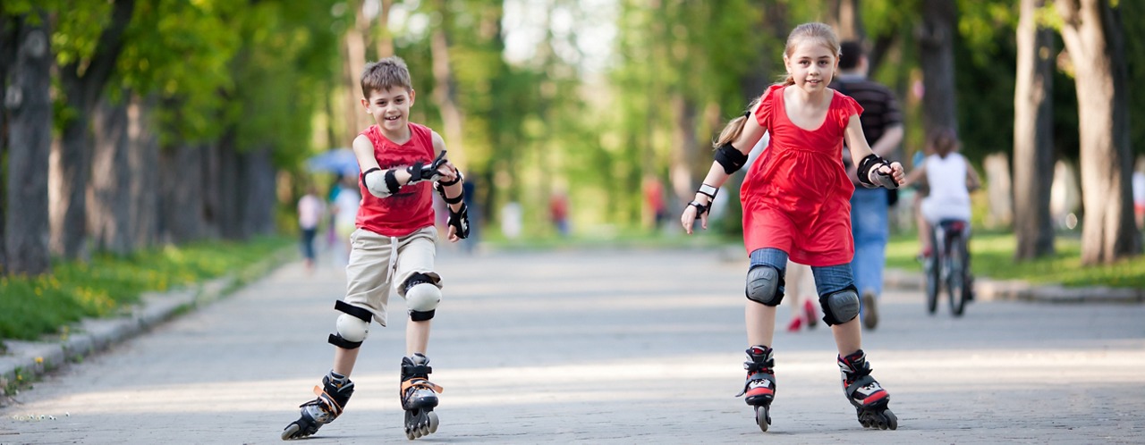 Little boy and girl on rollerblades competing