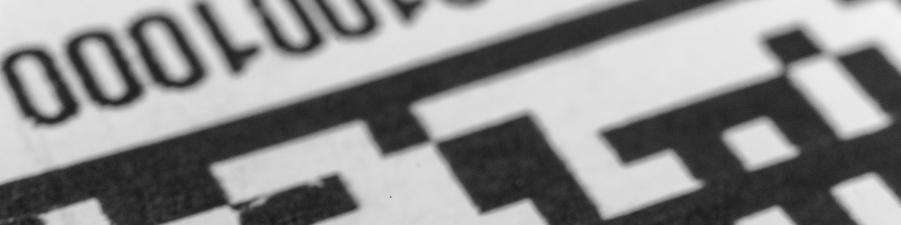 Abstract monochrome close up of isolated printed QR data matrix bar code on white paper label background from material inventory tracking system