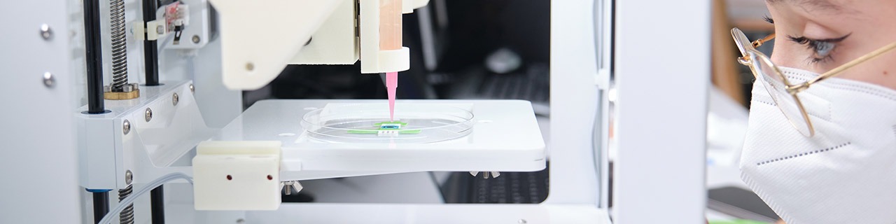 Chercheuse ajustant une bio-imprimante 3D pour imprimer des cellules en 3D sur une électrode