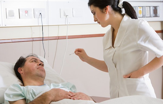 Nurse taking temperature of patient