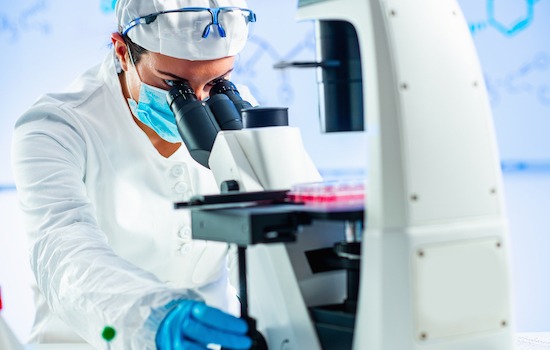  Biology researcher looking through microscope