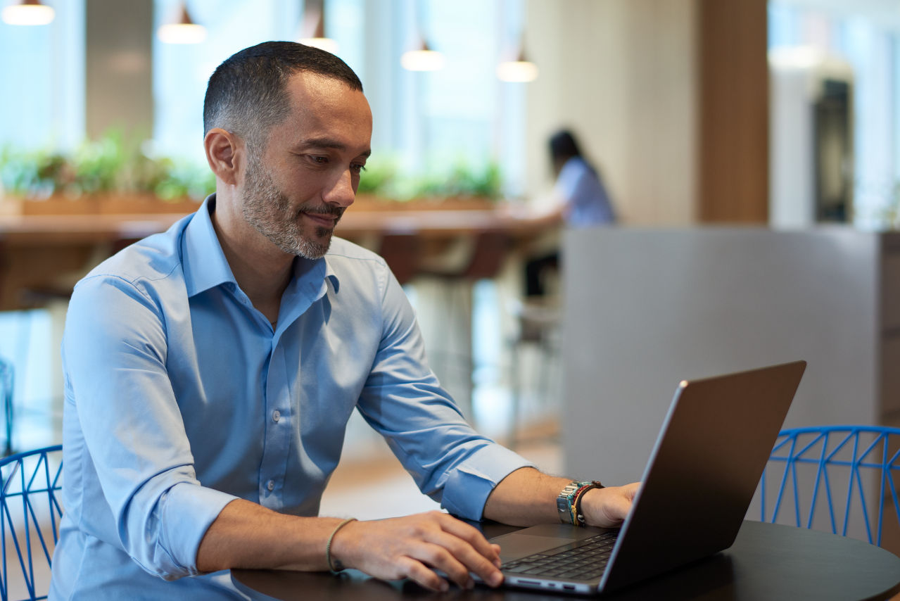 Man working on laptop in cafe