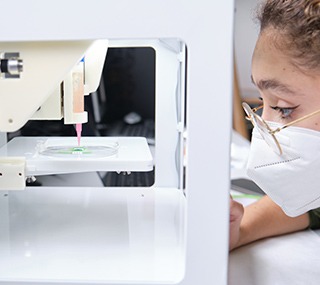 Chercheuse ajustant une bio-imprimante 3D pour imprimer des cellules en 3D sur une électrode