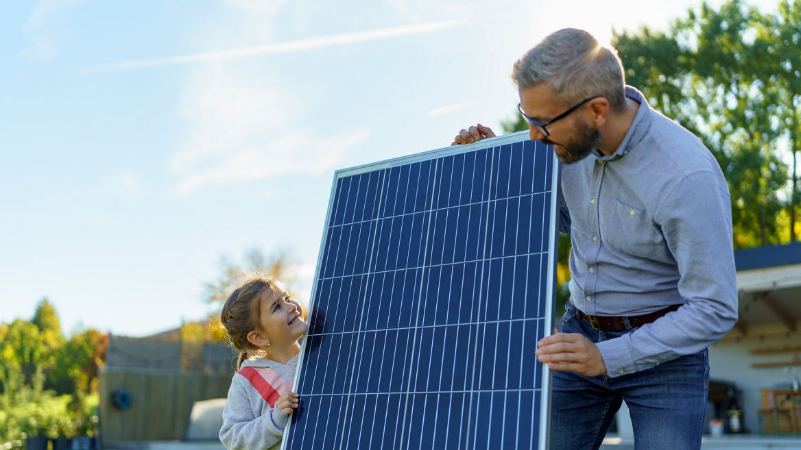 Vater zeigt seiner Tochter ein Solarpanel