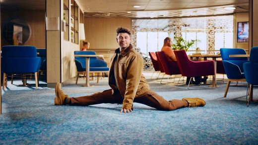 Man stretching in Stena Line ferry lounge, relaxed onboard travel atmosphere