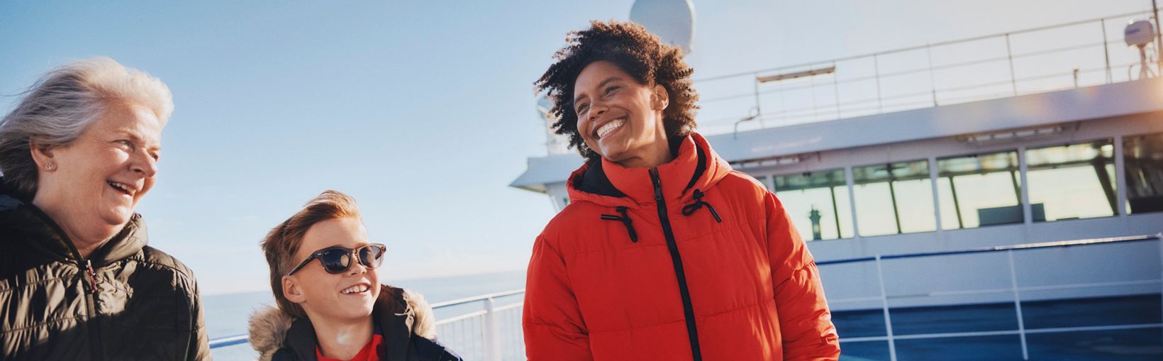 Leende familj på soldäck ombord på en Stena Line-färja som njuter av havsbrisen tillsammans