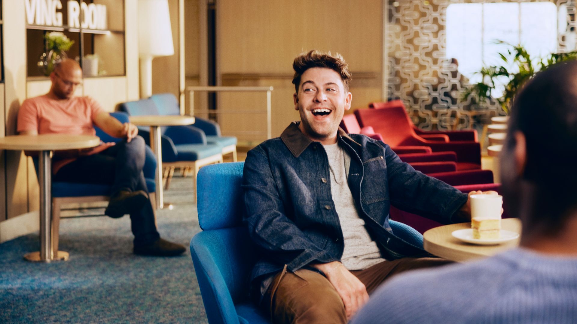 Man relaxing with coffee and cake in a Stena Line onboard lounge, enjoying calm ferry travel moments
