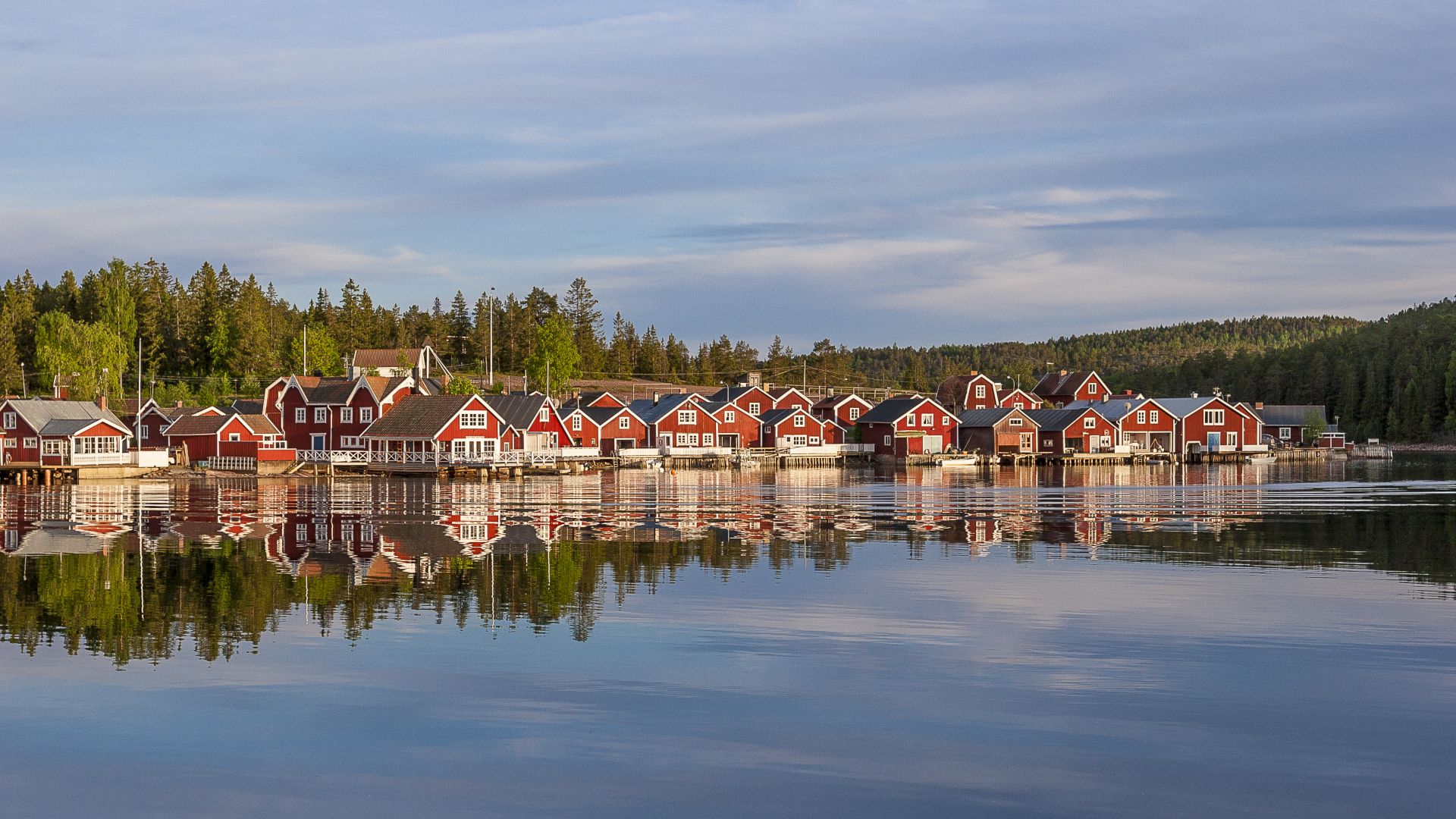 røde huse ved solnedgang i fiskerlandsbyen Norfaellsviken, Höga Kusten, Sverige