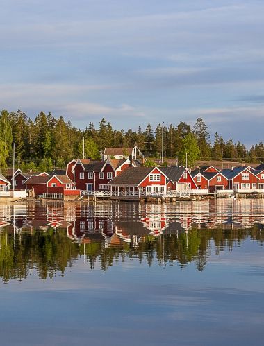 raudoni namai saulėlydžio metu Norfaellsviken žvejų kaime, Höga Kusten, Švedija