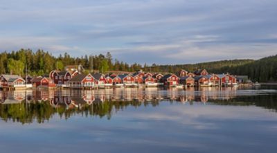 punased majad päikeseloojangul Norfaellsvikeni, Höga Kusten, Rootsi kalakülas