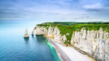 Etretat Aval cliff, rocks and natural arch landmark and blue ocean. Aerial view. Normandy, France, Europe.