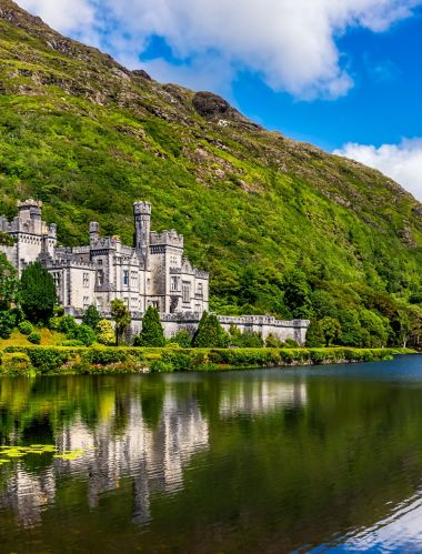 Panorama of Kylemore Abbey, beautiful castle like abbey reflected in lake at the foot of a mountain. Benedictine monastery, in Connemara, Ireland