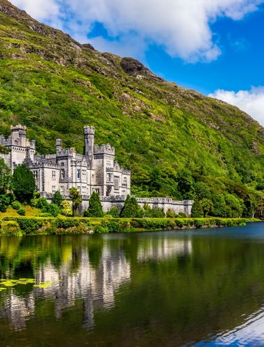 Panorama of Kylemore Abbey, beautiful castle like abbey reflected in lake at the foot of a mountain. Benedictine monastery, in Connemara, Ireland