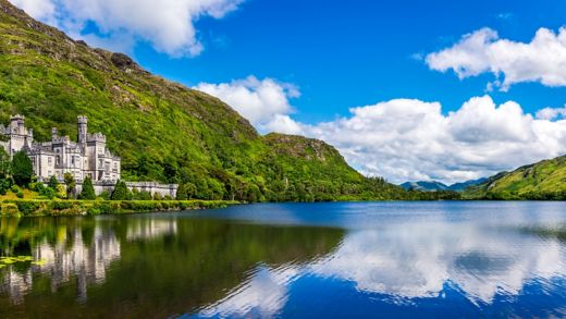 Panorama of Kylemore Abbey, beautiful castle like abbey reflected in lake at the foot of a mountain. Benedictine monastery, in Connemara, Ireland