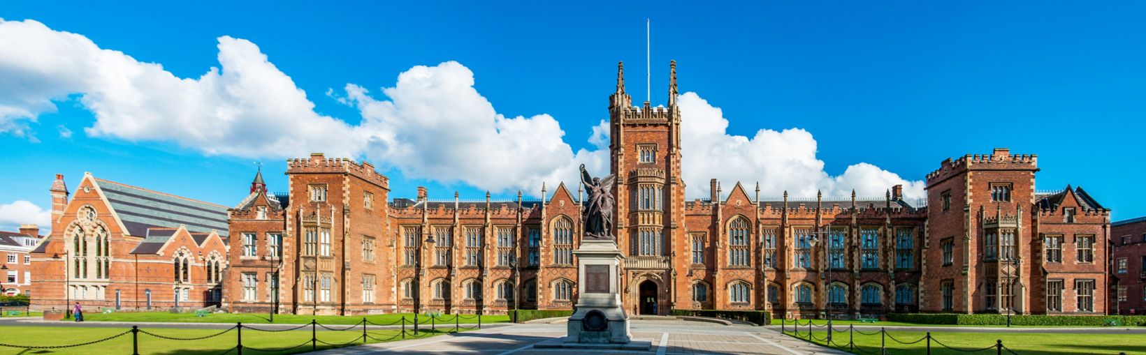 The Queen's University of Belfast with a grass lawn in sunset light. Wide panorama, 