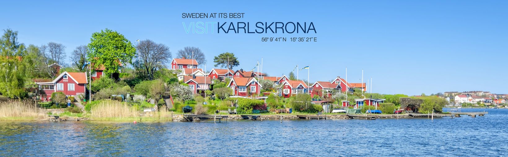 Panorama of traditional buildings with red walls and roofs on the coast of Karlskrona at Brandaholm peninsula