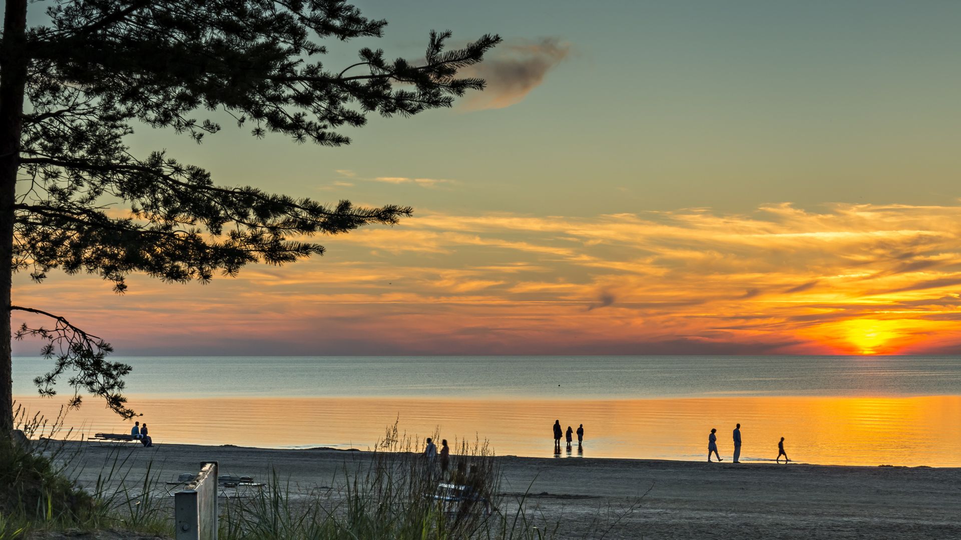 Farbenfroher Sonnenuntergang am Sandstrand von Jurmala – dem berühmten Badeort im Baltikum, Lettland.
