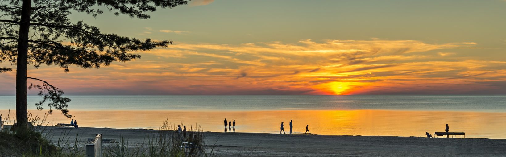 Farbenfroher Sonnenuntergang am Sandstrand von Jurmala – dem berühmten Badeort im Baltikum, Lettland.