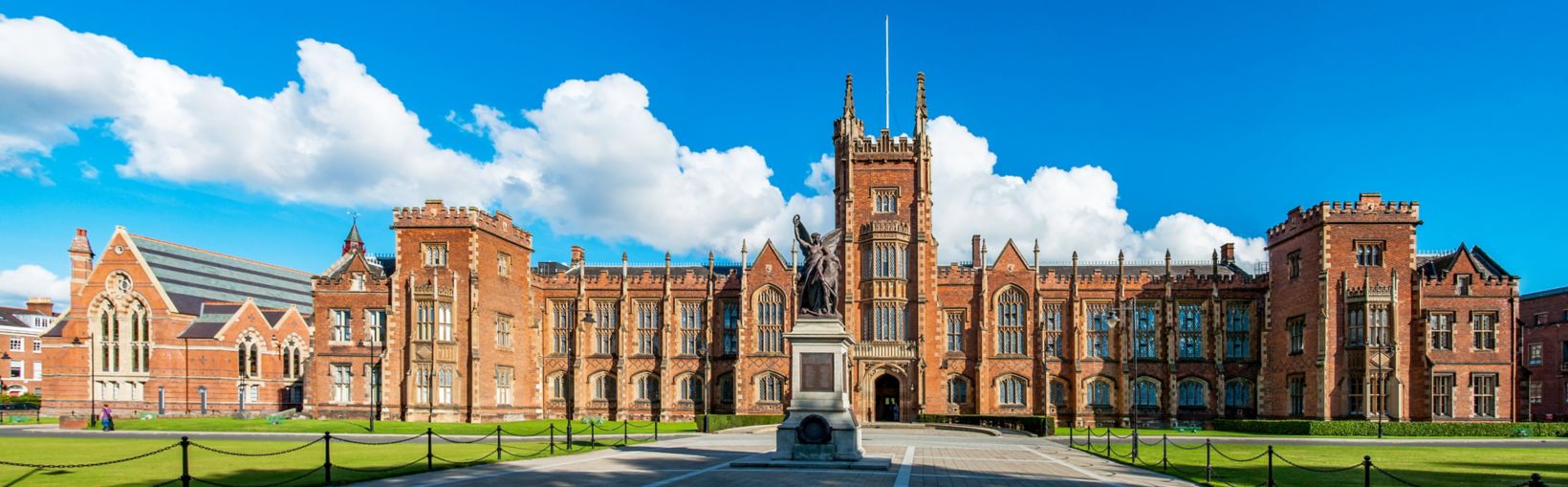 The Queen's University of Belfast with a grass lawn in sunset light. Wide panorama, 