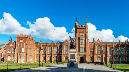 The Queen's University of Belfast with a grass lawn in sunset light. Wide panorama, 